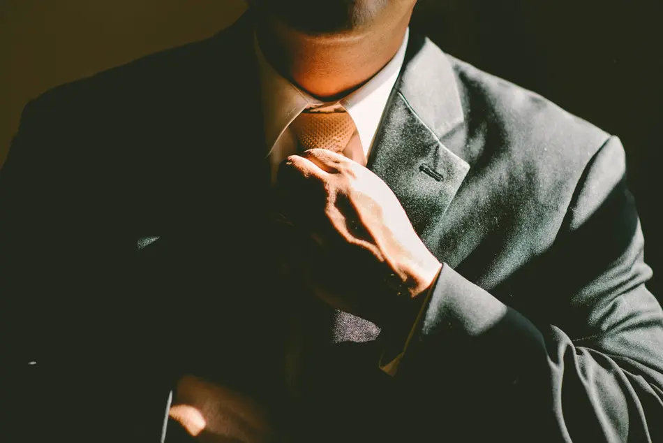 Tailor adjusting a suit jacket in London studio